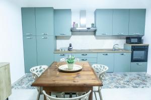 a kitchen with blue cabinets and a wooden table at Cerenea House BiancAntò in Isola del Liri