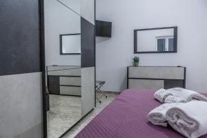 a bedroom with a purple bed and a mirror at Cerenea House BiancAntò in Isola del Liri