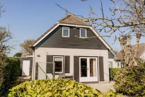 a house with a black and white house at Vakantiehuis dicht bij het strand in Ouddorp