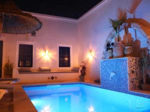 a large swimming pool in a room with a large swimming pool at TenasBook Houch Yassmine in Erriadh