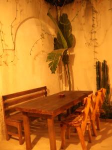 a wooden table and chairs in a room with a plant at TenasBook Houch Yassmine in Erriadh