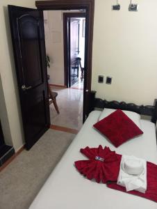 a bedroom with a bed with a red dress on it at Hotel Las Golondrinas in Puerto Berrío