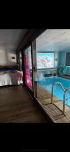 a bathroom with a tub in a room with a bed at Apartment enjoy and swim in Oslo