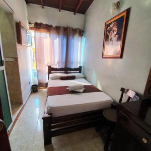 a bedroom with two beds and a window at Hotel Las Golondrinas in Puerto Berrío