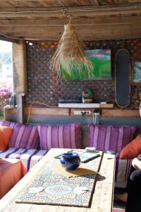 a table in a room with purple chairs and a tv at Nizar Surf Morocco in Taghazout