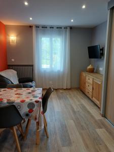a living room with a table and a television at Le Conty in Saint-Jorioz