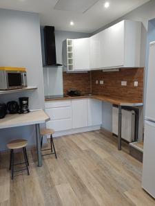 a kitchen with white cabinets and a table and chairs at Le Conty in Saint-Jorioz