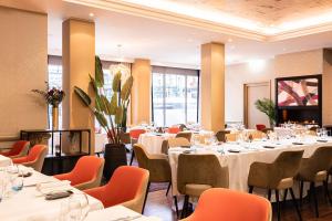 a dining room with white tables and orange chairs at Warwick Geneva in Geneva