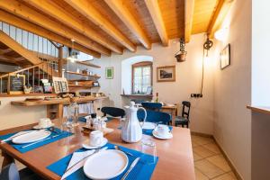 ein Esszimmer mit einem Holztisch mit blauen Servietten in der Unterkunft B&B Arlanch 8 in Vallarsa