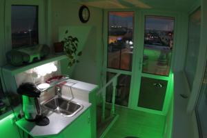 cocina verde con fregadero y ventana en Mansarda, en San Petersburgo