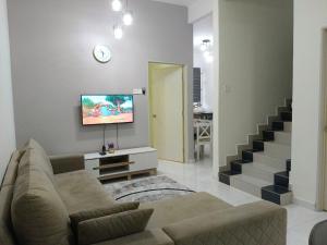 a living room with a couch and a tv at IB Indah Home Kangar in Kangar