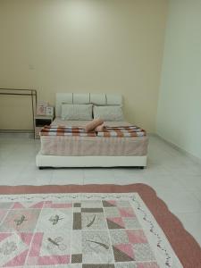 a bed in a bedroom with a rug on the floor at IB Indah Home Kangar in Kangar
