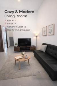 a living room with a black couch and a coffee table at Lot 766, Langkawi in Pulau Langkawi