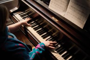 a young child playing a piano at Burnhopeside Hall in Lanchester