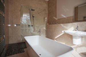 a bathroom with a tub and a sink and a shower at Burnhopeside Hall in Lanchester +21 photos