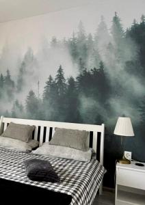 a bedroom with a forest mural on the wall at Waterfall apartment in Plitvička Jezera +1 photo