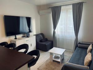 a living room with a tv and a couch and chairs at Waterfall apartment in Plitvička Jezera