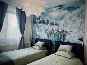 a bedroom with two beds and a painting on the wall at Waterfall apartment in Plitvička Jezera