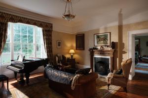 a living room with a piano and a couch at Burnhopeside Hall in Lanchester