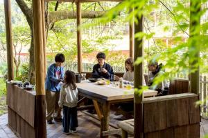 a group of people standing around a wooden table at Nagi no Ne in Washika