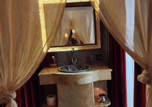 a bathroom with a sink and a mirror at Sahara Legacy Camp in Merzouga