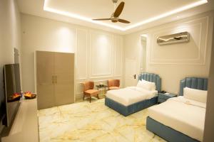 a hotel room with two beds and a table at The Edition Signature in Bahawalpur