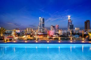 a swimming pool with a city skyline at night at Happy Life Grand Hotel & Rooftop Skybar in Ho Chi Minh City