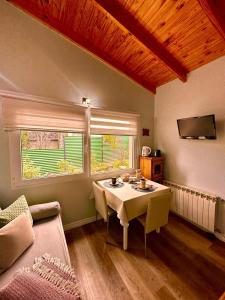 a living room with a table and a couch at Buenavida Guesthouse in Ushuaia