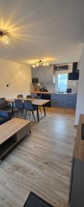 a room with tables and chairs and a kitchen at Kameralne Kładno in Łopienica