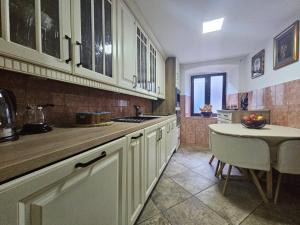 a kitchen with white cabinets and a table in it at Casa Di Kotor in Kotor +11 photos