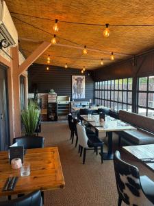 a dining room with tables and chairs and windows at Fuego Steakhouse and Tapas -Tomahawk Potto in Potto