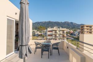 a patio with chairs and a table on a balcony at Casa John Kos Apartment in Zipárion