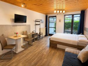 a hotel room with a bed and a desk and a kitchen at Ferienwohnungen auf Reiterhof in Kevelaer in Kevelaer