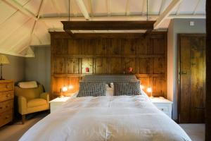 a bedroom with a large bed with a wooden headboard at Lanes End by Keepers Cottages in Woodchurch +37 photos