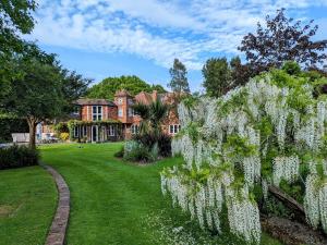 a garden in front of a house with white flowers at Lanes End by Keepers Cottages in Woodchurch