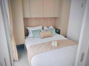 a bed with two slippers sitting on top of it at Mobile Home Camp Dalmata Orebić in Orebić