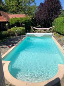 a large blue swimming pool with a chair in a yard at Lanes End by Keepers Cottages in Woodchurch