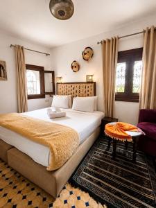 a bedroom with a large bed and a table at Riad Zaitouna Chaouen in Chefchaouen