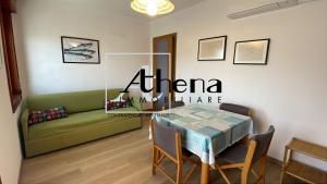 a living room with a green couch and a table at Sole in Grado +12 photos