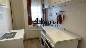 a kitchen with a washing machine and a window at Sole in Grado