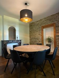 a dining room with a wooden table and chairs at Le Clos des Marronniers in Léglise