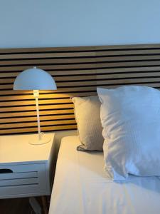 a bed with a lamp on a table next to it at Humble Kro og Hotel in Humble