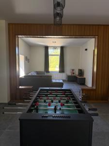 a living room with a pool table in the middle at Le Clos des Marronniers in Léglise