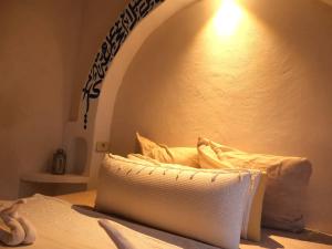 a room with a bed with a white pillow at TenasBook Houch Yassmine in Erriadh