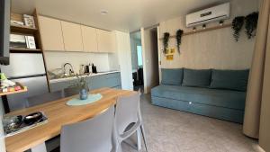 a kitchen and living room with a table and a couch at Mobile Home Camp Dalmata Orebić in Orebić