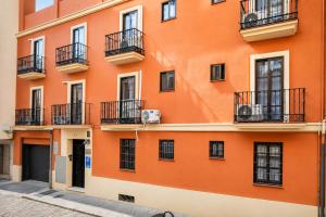 an orange building with balconies on a street at Casa Lavanda by Blossom Hotels in Granada +34 photos