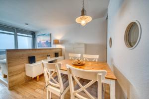a kitchen and dining room with a wooden table and chairs at Ferienpark - Haus H, App 0H1107 - Apartment Baltic Panorama in Heiligenhafen