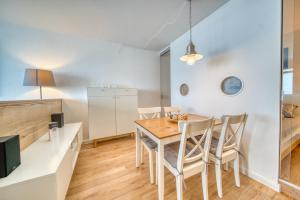 a kitchen and dining room with a wooden table and chairs at Ferienpark - Haus H, App 0H1107 - Apartment Baltic Panorama in Heiligenhafen +8 photos