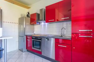 a kitchen with red cabinets and a sink at Ferienwohnung Schlossperle in Klütz