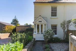 a white house with a white door at Pebble Beach Cottage by Keepers Cottages in Kingsdown